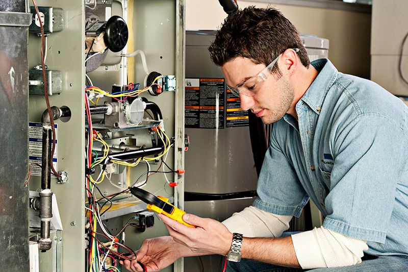 Image of a technician working on an AC unit. Why Do I Need AC Maintenance Now?